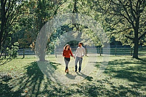 Happy couple man and woman in love walking in park outdoor. Lovely beautiful Caucasian heterosexual people dating walking on an