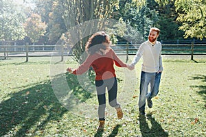 Happy couple man and woman in love walking in park outdoor. Lovely beautiful Caucasian heterosexual people dating walking on an