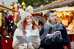 Happy couple with map and city guide in old town