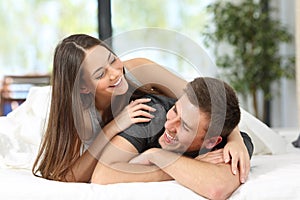 Happy couple or marriage joking on the bed photo