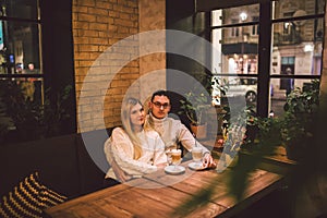 Happy Couple Meeting And Drinking Coffee. love and romantic date in downtown cafe restaurant. Young happy couple in love