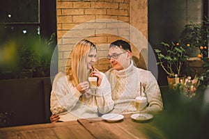 Happy Couple Meeting And Drinking Coffee. love and romantic date in downtown cafe restaurant. Young happy couple in love in cafe.