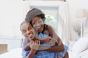 Happy couple messing about on their bed