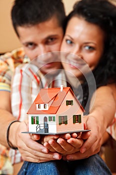 Happy couple with miniature house