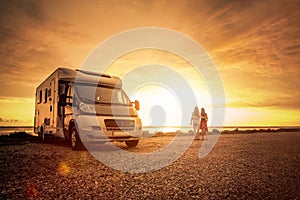 Happy couple with mobile home on the beach photo