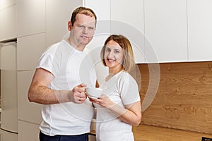 Happy Couple with Morning Tea in Modern Kitchen