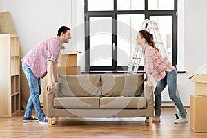 Happy couple moving sofa at new home