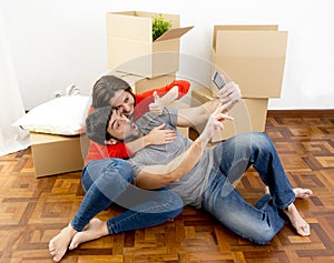 Happy couple moving together in a new house taking selfie video and pic