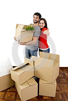 Happy couple moving together in a new house unpacking cardboard boxes