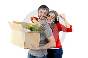 Happy couple moving together in a new house unpacking cardboard boxes