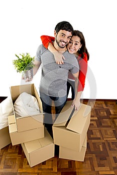 Happy couple moving together in a new house unpacking cardboard boxes