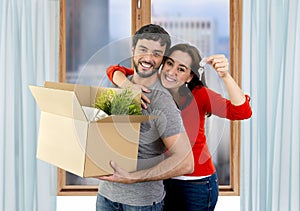 Happy couple moving together in a new house unpacking cardboard boxes