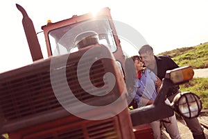 Happy couple near tractor on farm