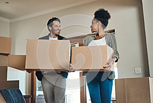 Happy couple or new home owners moving in together, carrying boxes of furniture or belongings and property. Loving