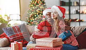 Happy couple opening presents on Christmas morning