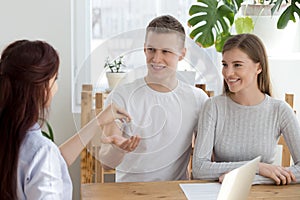 Happy couple owners get keys to new house from realtor