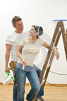 Happy couple painting first home