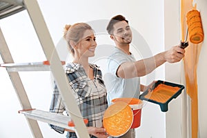 Happy couple painting wall. Home repair