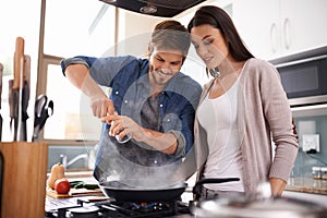 Happy couple, pan and cooking together in the kitchen with food or healthy ingredients for dinner at home. Man and woman