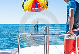 Happy couple Parasailing in Dominicana beach in summer. Couple under parachute hanging mid air. Having fun. Paradise. Pos photo