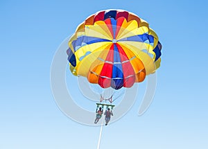 Happy couple Parasailing in Dominicana beach in summer. Couple under parachute hanging mid air. Having fun. Tropical Paradise. Pos