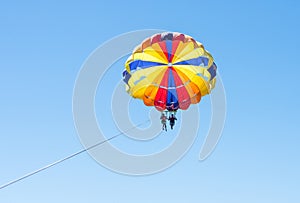 Happy couple Parasailing in Dominicana beach in summer. Couple under parachute hanging mid air. Having fun. Tropical Paradise. Pos