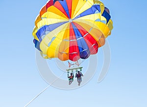 Happy couple Parasailing in Dominicana beach in summer. Couple under parachute hanging mid air. Having fun. Tropical Paradise. Pos photo