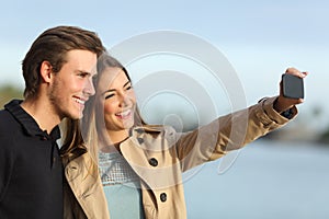 Happy couple photographing a selfie with the smart phone