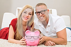 Happy couple with piggybank photo