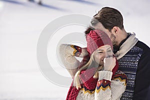 Happy couple playful together during winter holidays vacation outside in snow park