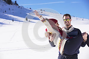 Happy couple playful together during winter holidays vacation outside in snow park