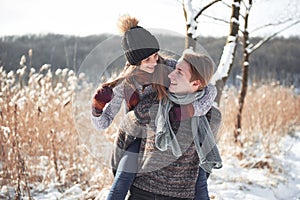 Happy couple playful together during winter holidays vacation outside in snow park