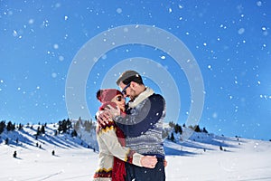 Happy couple playful together during winter holidays vacation outside in snow park