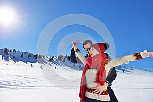 Happy couple playful together during winter holidays vacation outside in snow park