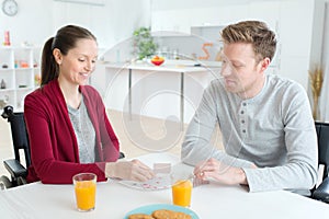 Happy couple playing cards at home she disabled