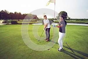 Happy couple playing golf at the club