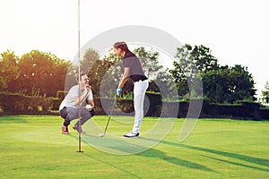 Happy couple playing golf at the club
