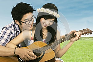 Happy couple playing guitar
