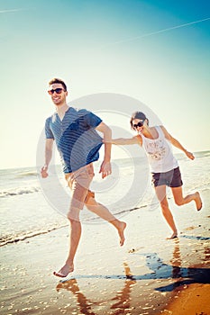 Happy couple playing on the seashore