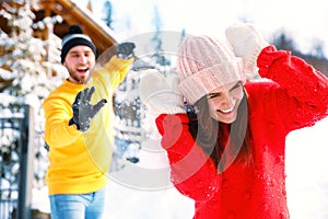 Happy couple playing snowballs. Winter vacation