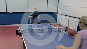 Happy couple playing the table tennis at the court