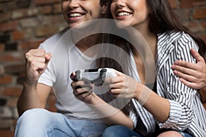 Happy couple playing video games together at home, closeup