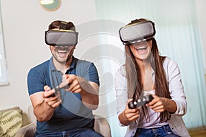 Happy couple playing video games virtual reality glasses. Couple having fun with new trends technology