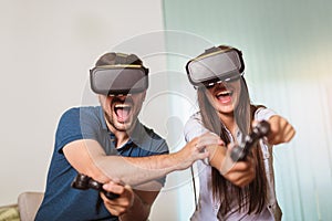 Happy couple playing video games virtual reality glasses. Couple having fun with new trends technology