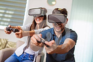 Happy couple playing video games virtual reality glasses. Couple having fun with new trends technology