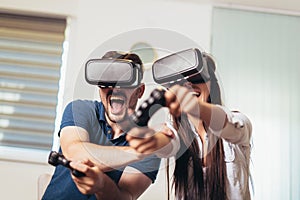 Happy couple playing video games virtual reality glasses. Couple having fun with new trends technology