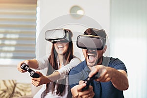Happy couple playing video games virtual reality glasses. Couple having fun with new trends technology. Selective focus