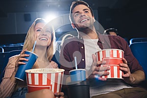 happy couple with popcorn watching film together photo