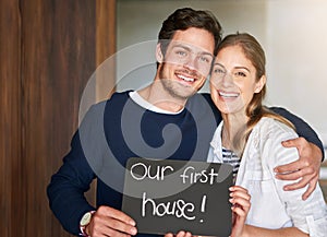 Happy couple, portrait and moving in new home with sign, hug or embrace for love, bonding or apartment. Young man and