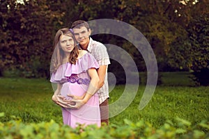 Happy couple posing in the Park in anticipation of the child. Ma